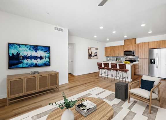 A modern living room with a wooden floor and a large flat screen TV mounted on the wall.