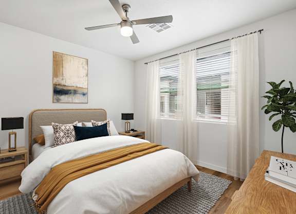 A bedroom with a large bed and a ceiling fan.