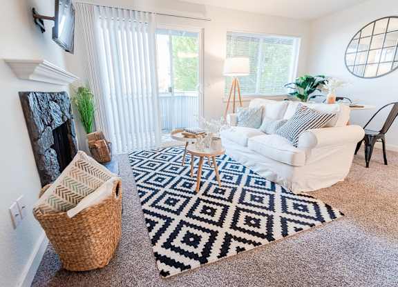 living room with couch and tv with balcony view at ReVive Apartments, Fife, WA