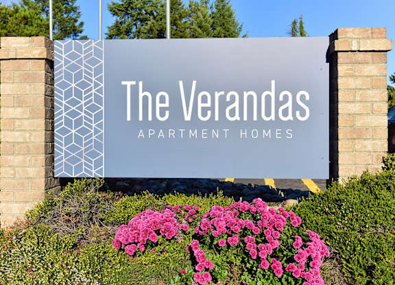 A sign for The Verandas Apartment Homes is displayed in front of a building.