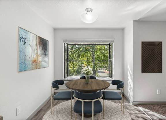 A dining room with a round table and chairs.