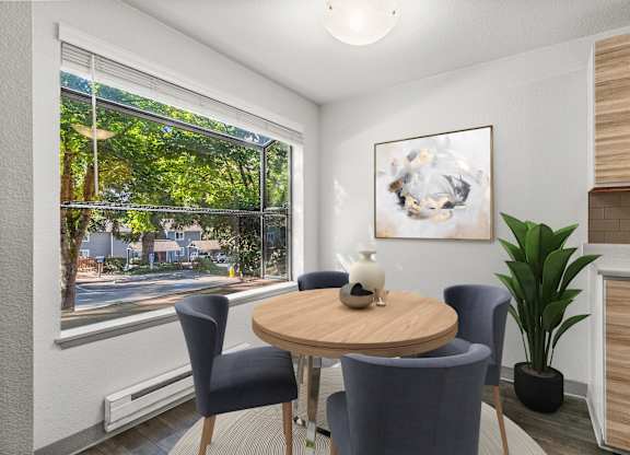 A room with a table, chairs, and a painting on the wall.