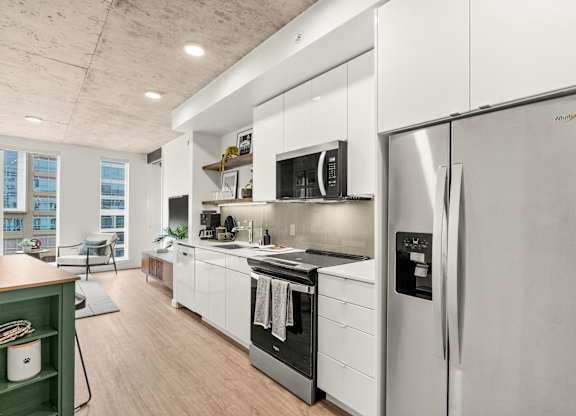 A modern kitchen with stainless steel appliances and white cabinets.