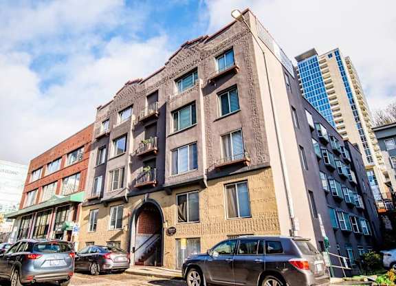A large, old building with a lot of windows is in front of a modern building. at Zindorf, Seattle, Washington