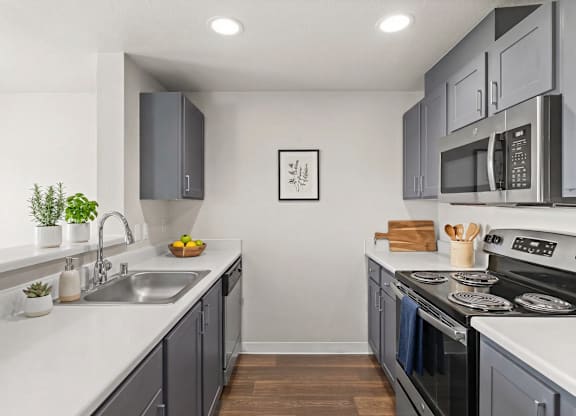 A modern kitchen with a stainless steel oven and microwave.