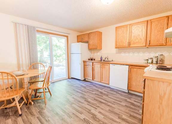 A kitchen with wooden cabinets and a white refrigerator. at The Retreat, Sumner, 98390