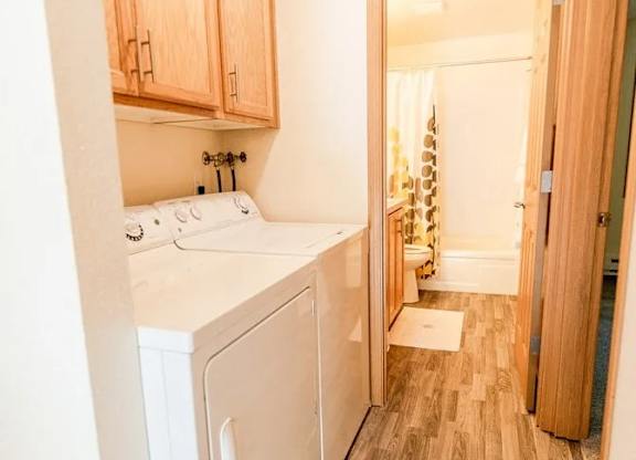 A small kitchen with a white fridge and wooden cabinets. at The Retreat, Washington, 98390