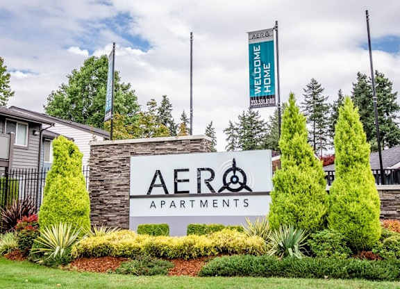 A sign for Aero Apartments is displayed in front of a building.