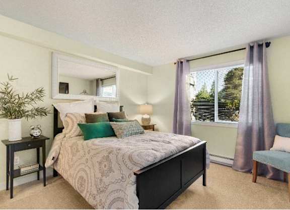 A bedroom with a large bed and a chair. at The Retreat, Sumner
