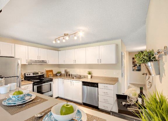 A modern kitchen with white cabinets and stainless steel appliances. at The Retreat, Washington, 98390