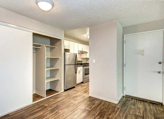 A kitchen with a refrigerator, oven, and cabinets. at The Lakes at Fife, Fife, 98424