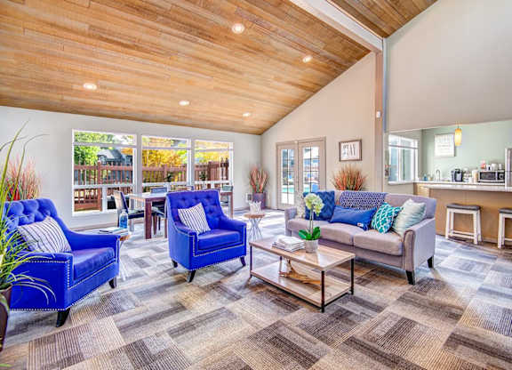 A living room with a blue chair and a grey couch. at The Lakes at Fife, Fife, 98424