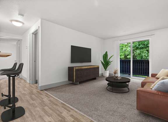 A living room with a brown leather couch, a black chair, a wooden entertainment center, and a large window with a view of greenery outside.