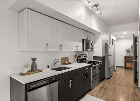 A modern kitchen with dark wood cabinets and stainless steel appliances.