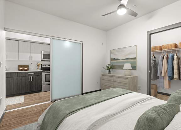 A bedroom with a bed, a wardrobe, and a kitchen area.