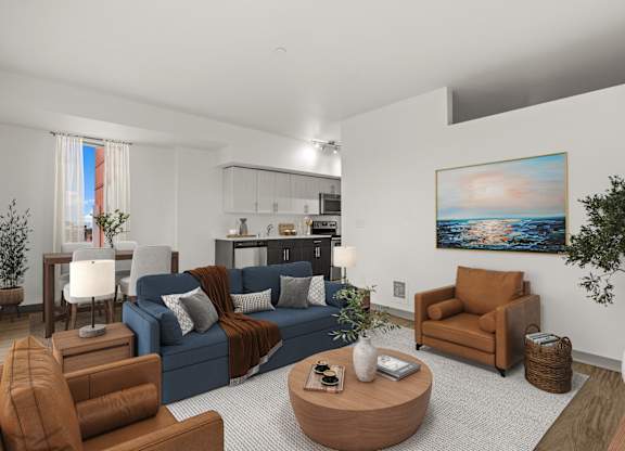 A living room with a blue couch, brown armchair, and a painting on the wall.