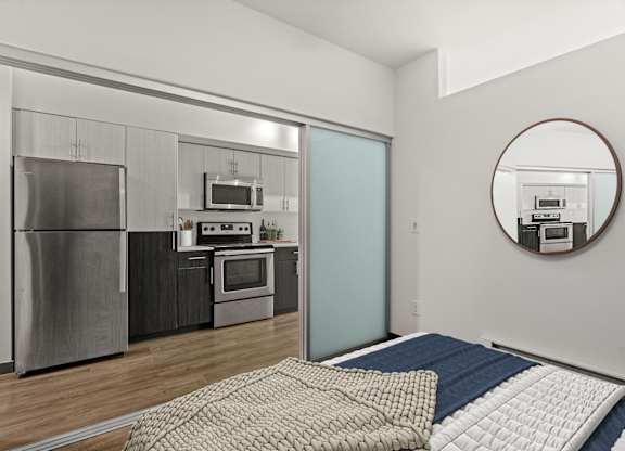 A modern kitchen with a refrigerator, oven, and microwave.