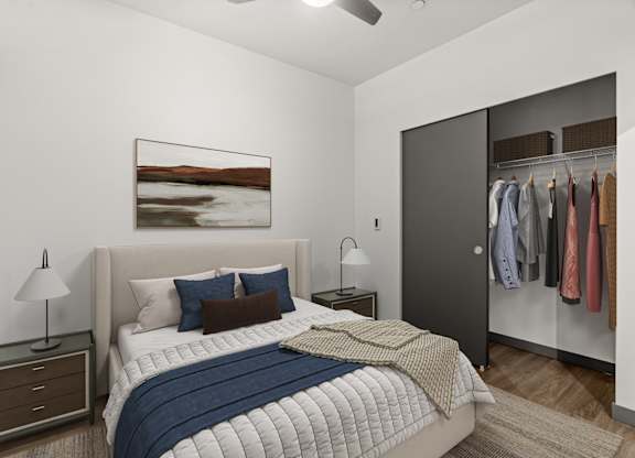 A bedroom with a bed, a nightstand, a ceiling fan, and a wardrobe.