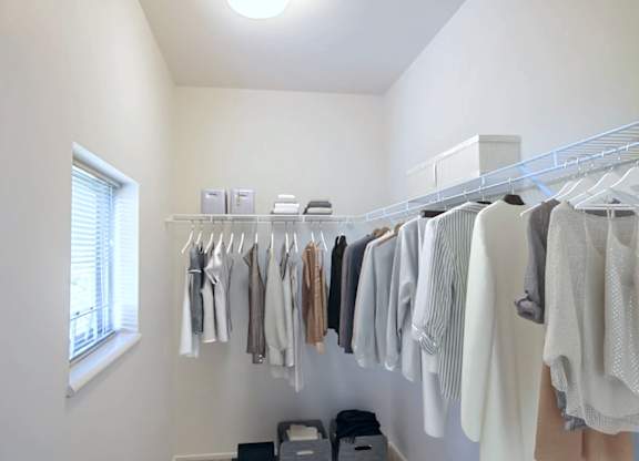 A row of clothes hanging on a rack in a room.