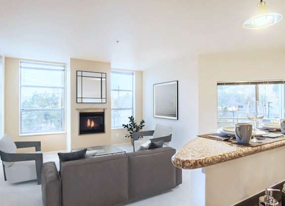 A living room with a fireplace and a grey couch.