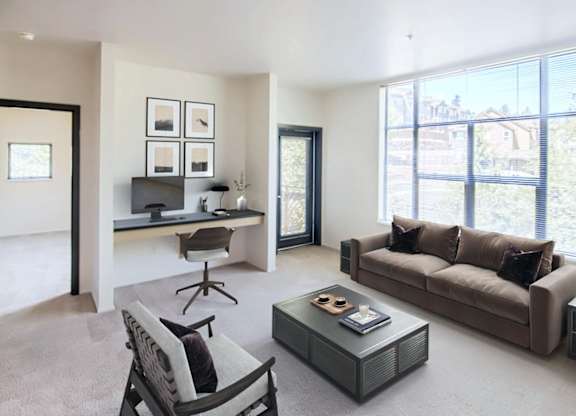 A living room with a brown couch, a coffee table, and a chair.