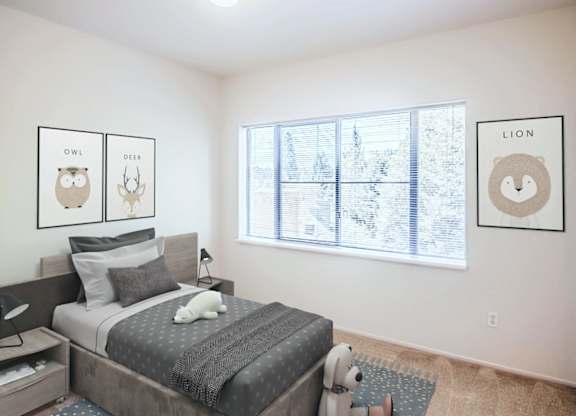 A bedroom with a bed, a window, and three framed pictures on the wall.