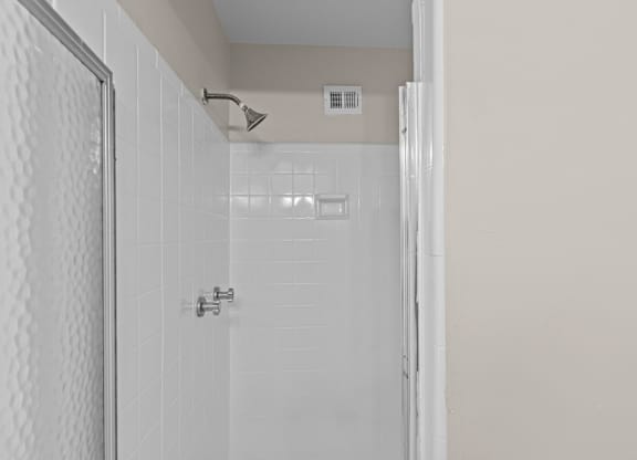 A white tiled shower with a silver faucet at Kensington House, Kensington