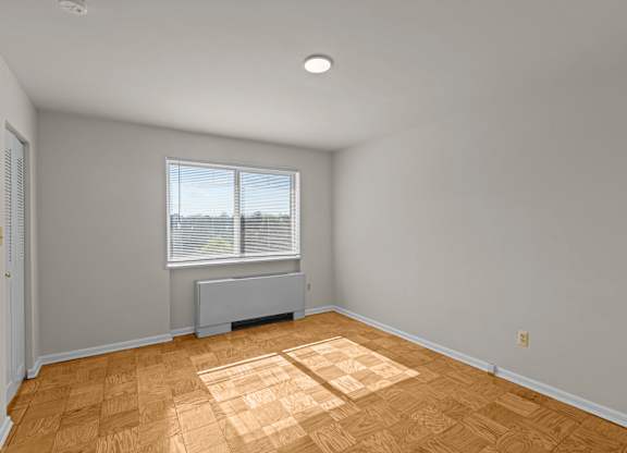 A room with wooden flooring and a window with blinds at Kensington House, Kensington, MD 20895