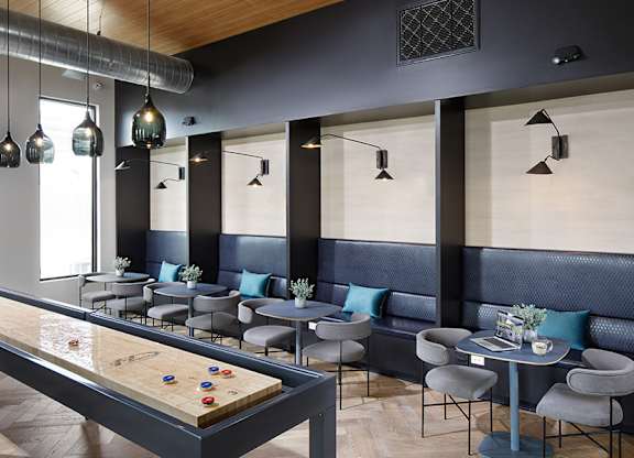 The game room features a lounge-style seating area and social environment
