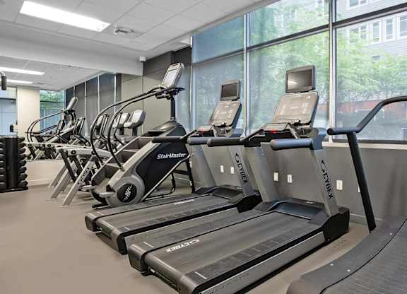 A gym with treadmills and elliptical machines.