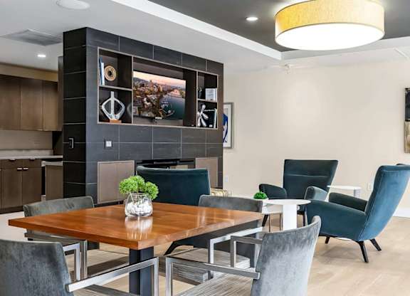 A modern dining room with a wooden table and grey chairs.