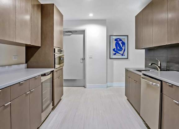 A kitchen with brown cabinets and a white counter top.
