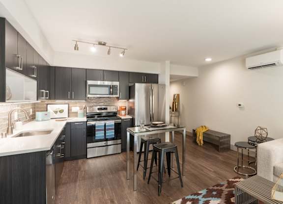 A modern kitchen with dark wood cabinets and a white countertop.