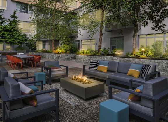 A modern outdoor seating area with a fire pit in the center.