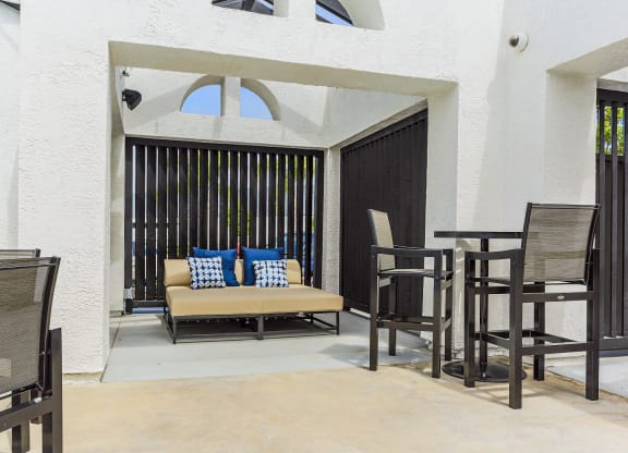 a patio with a couch and tables and chairs