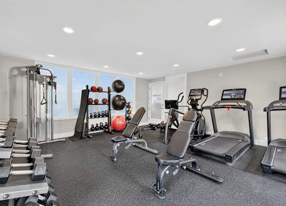 A well-equipped gym with a variety of exercise machines and weights.