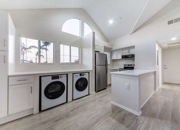 A modern laundry room with a washer and dryer in it.