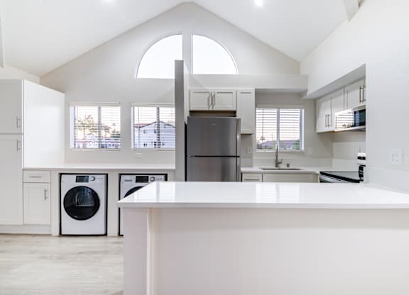 A modern kitchen with a large island and a refrigerator.