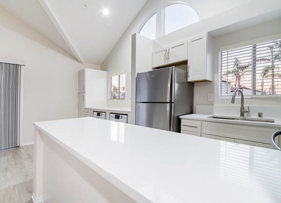 A modern kitchen with a large island and stainless steel appliances.