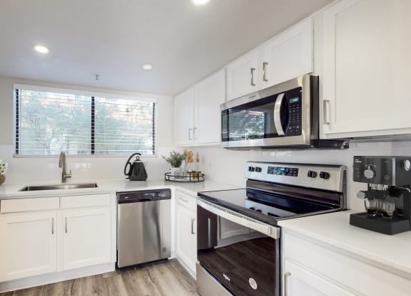 a kitchen with white cabinets and stainless steel appliances
