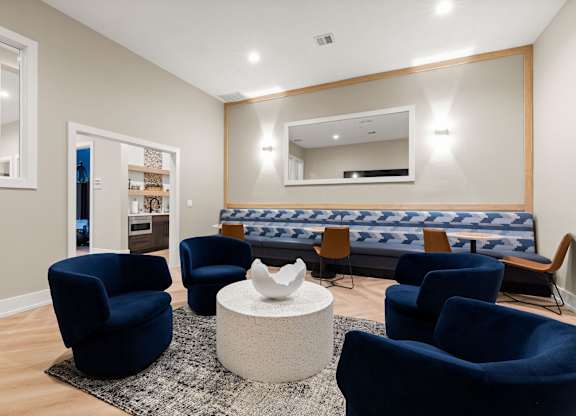 A living room with blue chairs and a white coffee table.