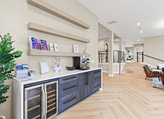 A modern kitchen with a wooden floor and a white wall.