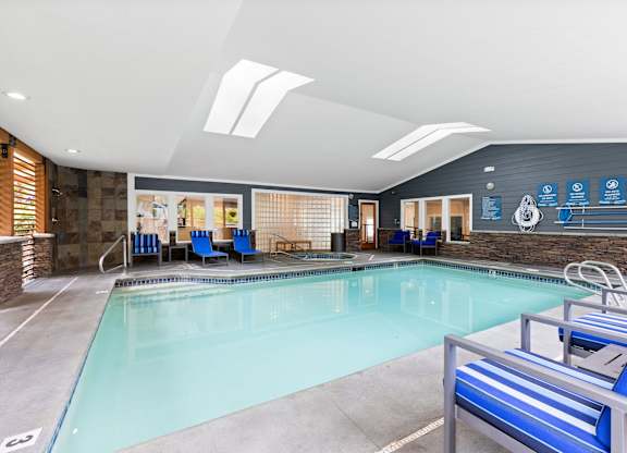 A large indoor swimming pool with a diving board.