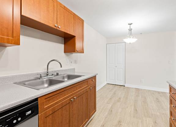 A kitchen with wooden cabinets and a white sink.