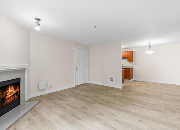 A room with a fireplace and wooden flooring.
