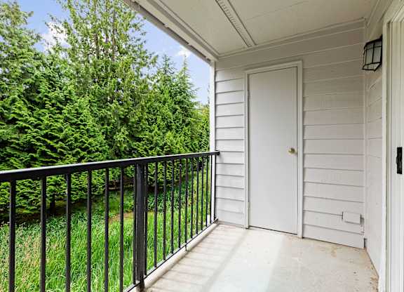 A white door is on the right side of a porch.