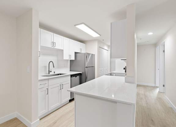 A modern kitchen with white cabinets and appliances.