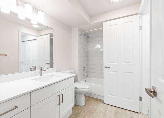 A white bathroom with a toilet, sink, and bathtub.
