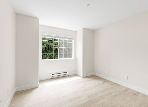 A room with a window and a wall-mounted air conditioner.