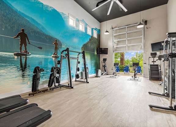 A gym with a large mural of people kayaking on a lake.